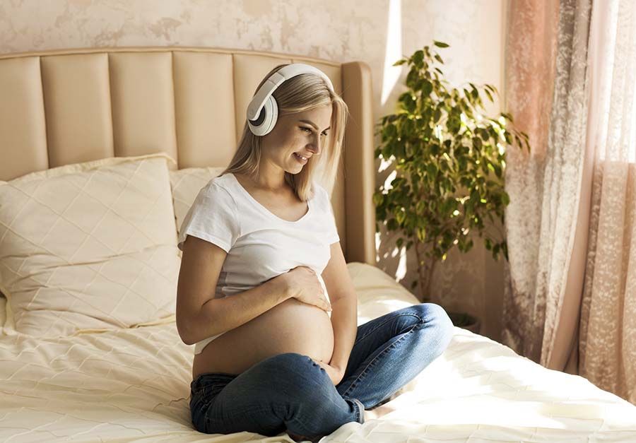 Mujer embarazada con audífonos